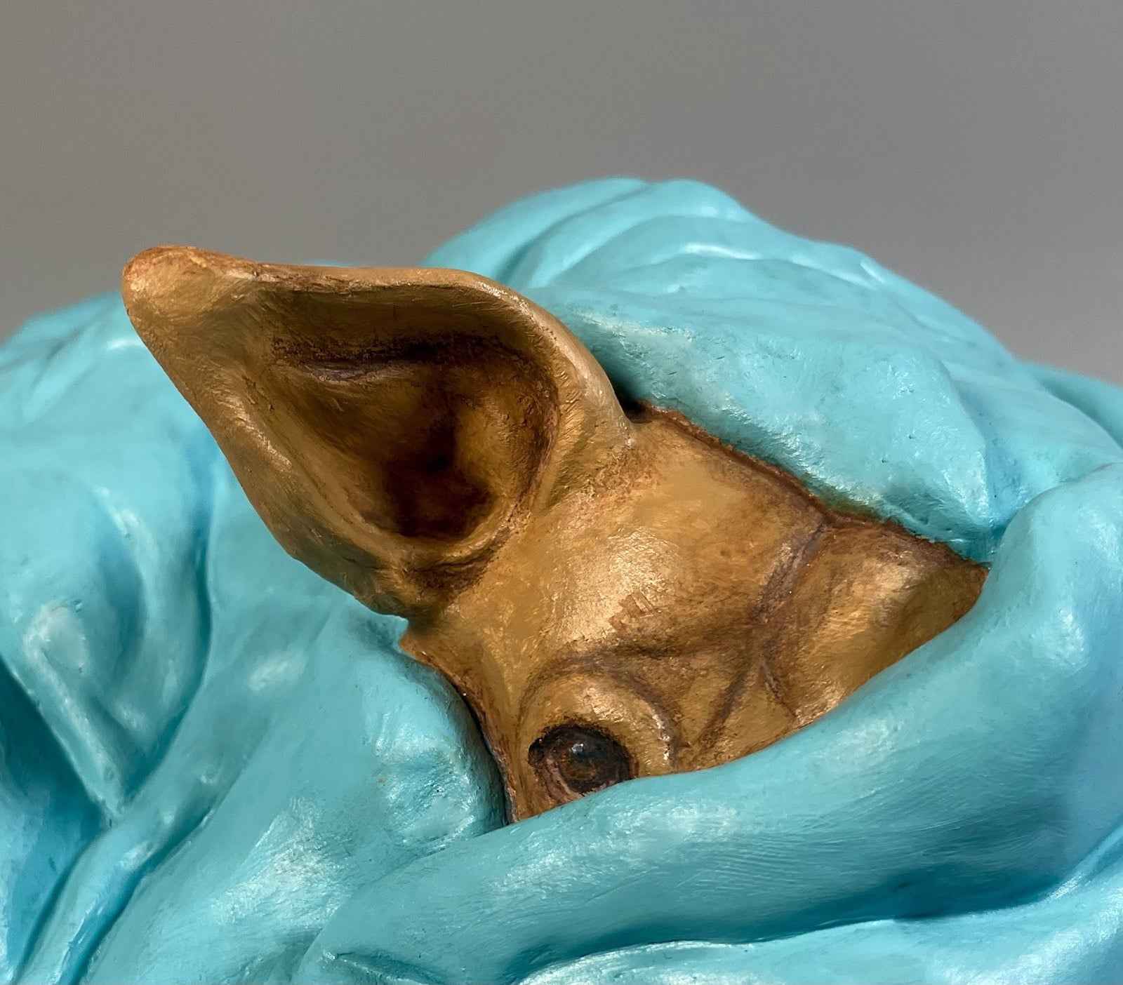 Detalle de cara, oreja y manta de la escultura Presencia paraíso, obra única de cerámica contemporánea